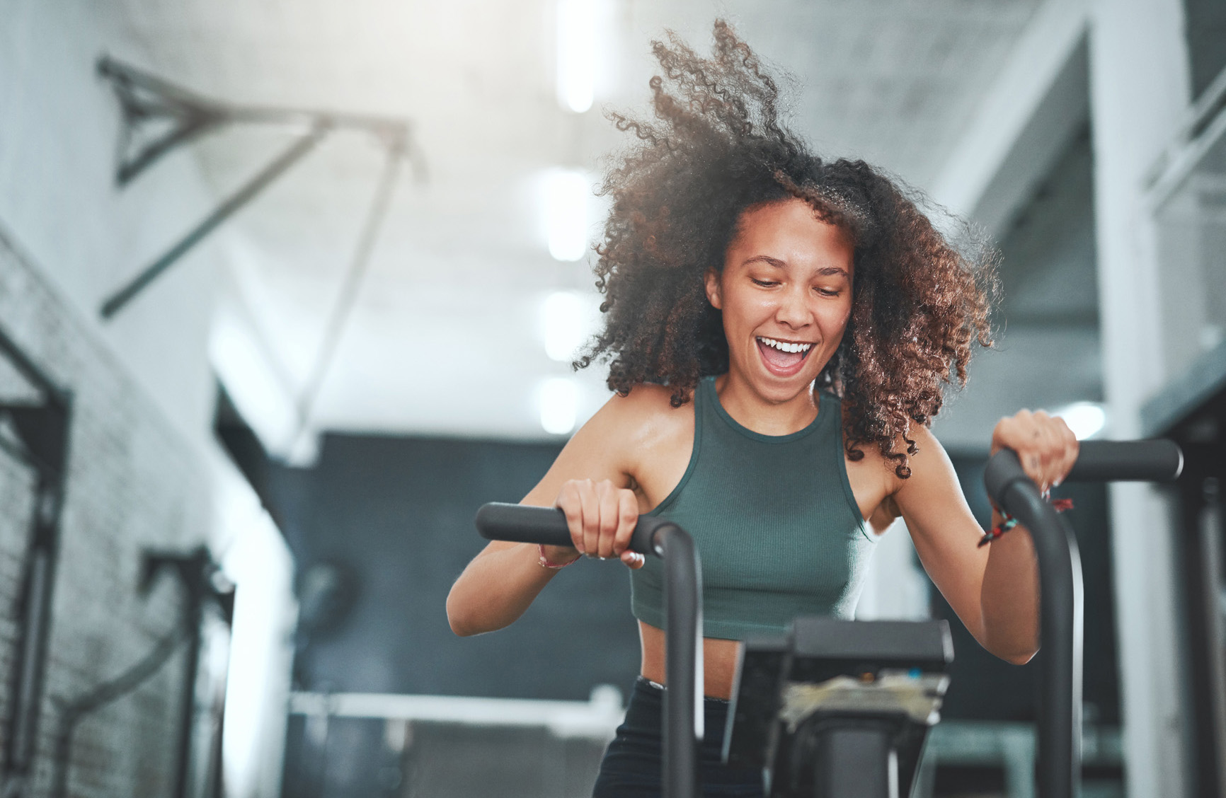 Shot of a young woman working out on an exercise bike in a gym